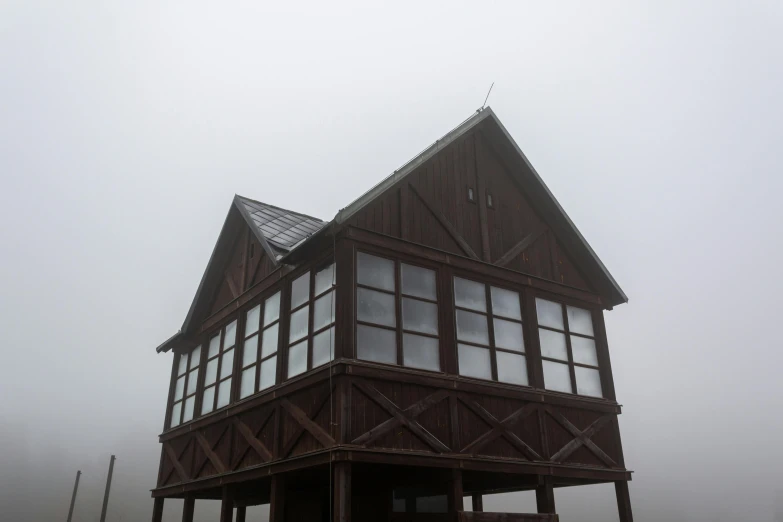 a dark colored house is shown in a foggy weather