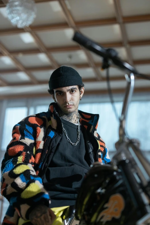 the young man is sitting next to his bicycle