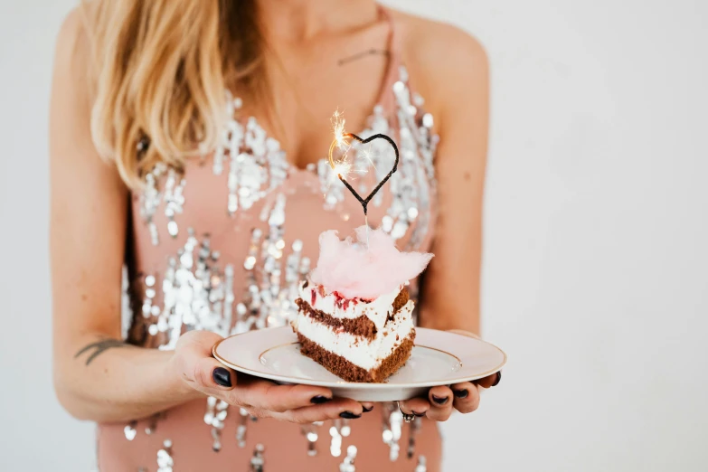 a woman holding a slice of cake in her hand
