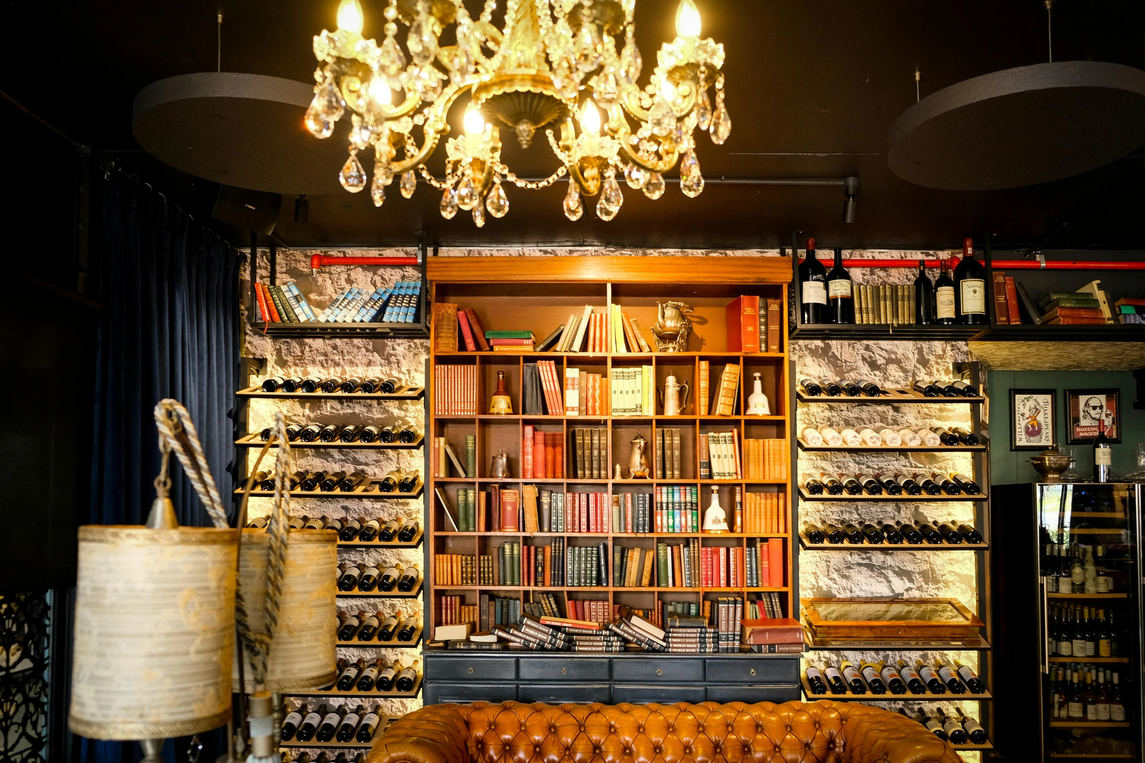 a leather couch sitting next to a lamp and a bookshelf