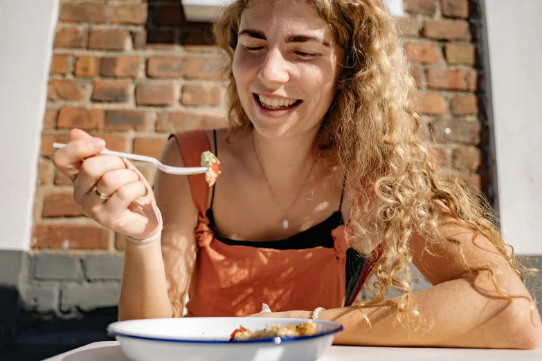 a woman eating out of a white bowl