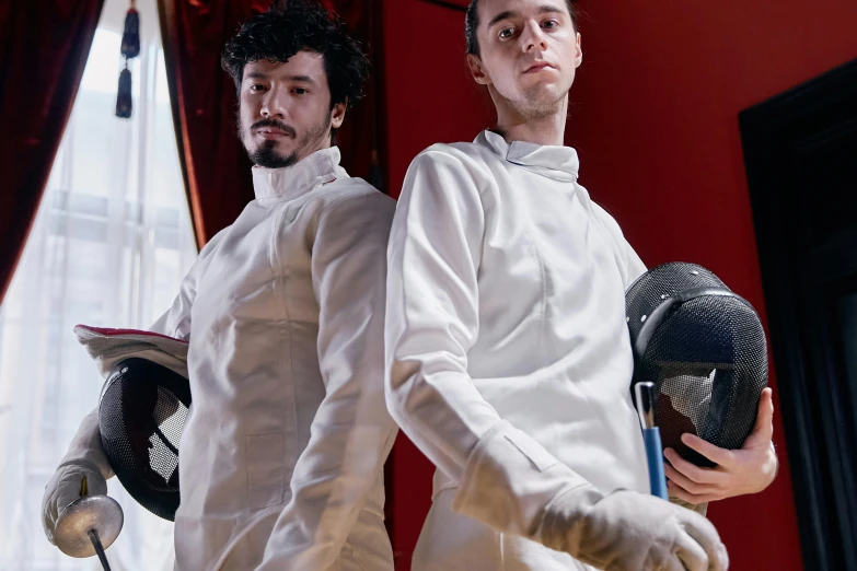 two men are wearing white shirts and holding helmets