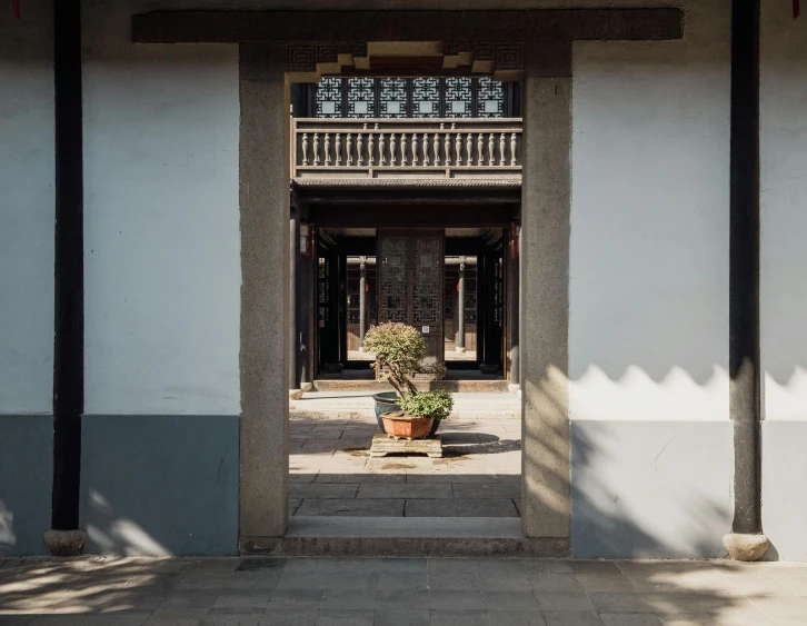 a building with a potted plant at the entrance