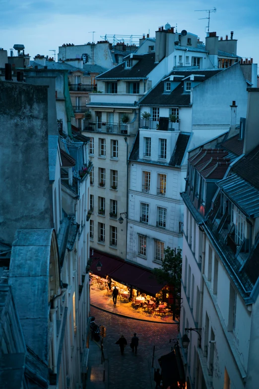 a narrow alley that has various buildings on top of it