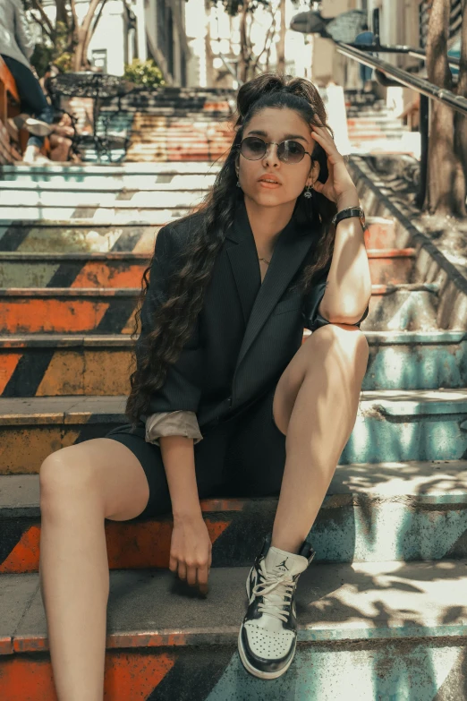 a young woman sitting on some stairs and talking on a cellphone