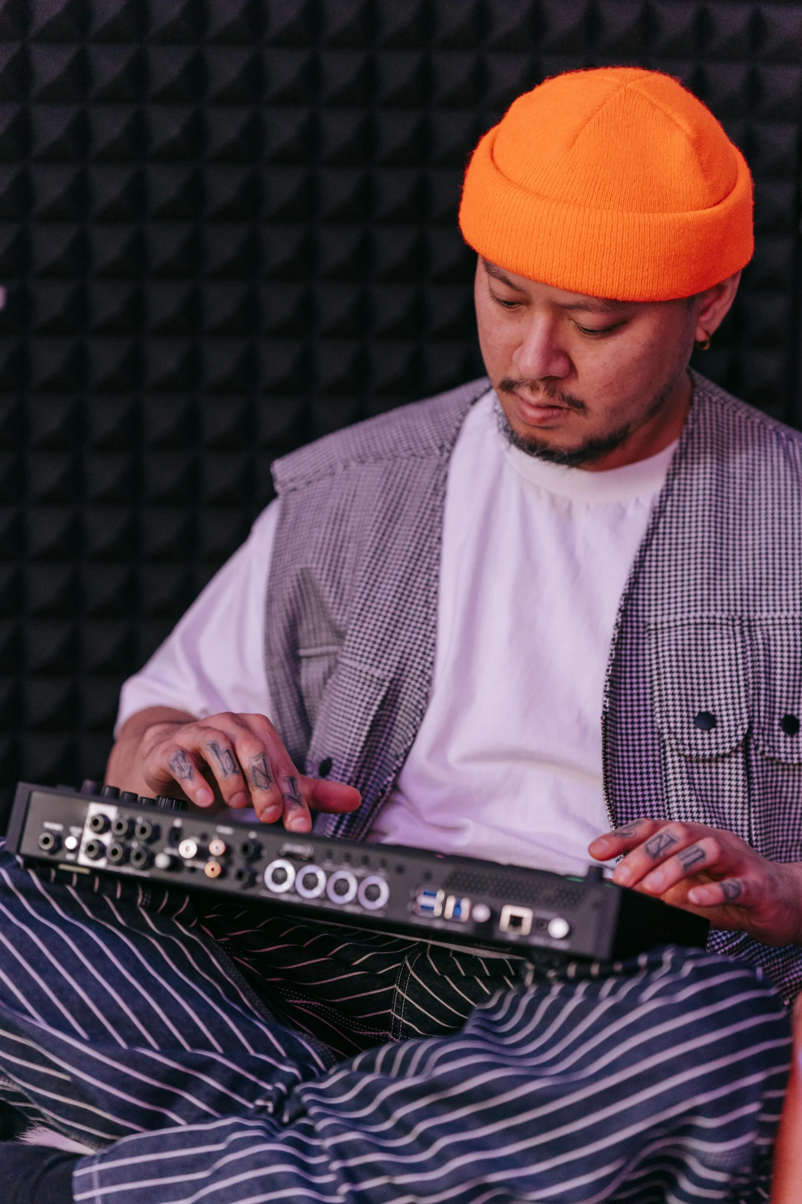 a person with an orange hat playing a keyboard