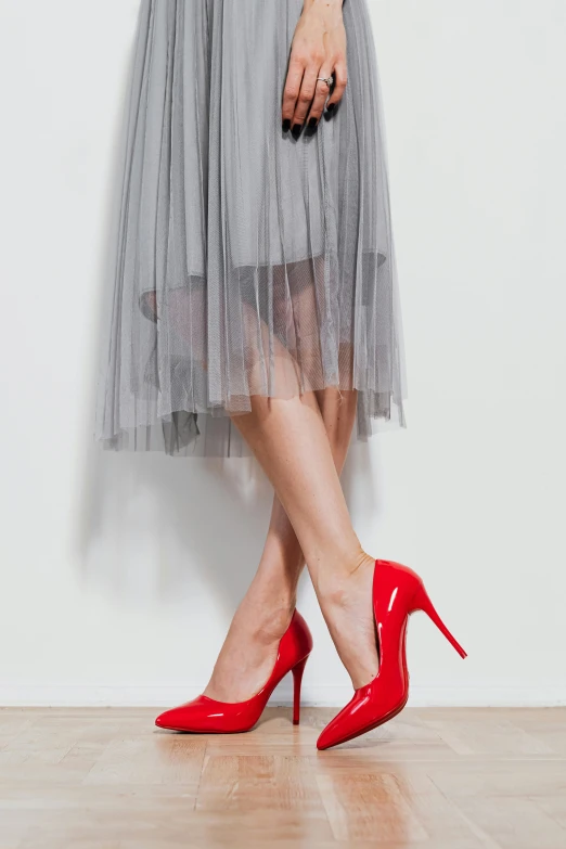 a woman in red shoes standing in a room