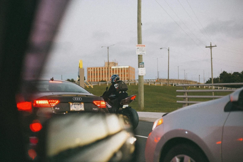 two motorcycles are riding in opposite directions as traffic waits