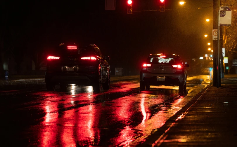 cars in the rain at night time traffic lights and signs