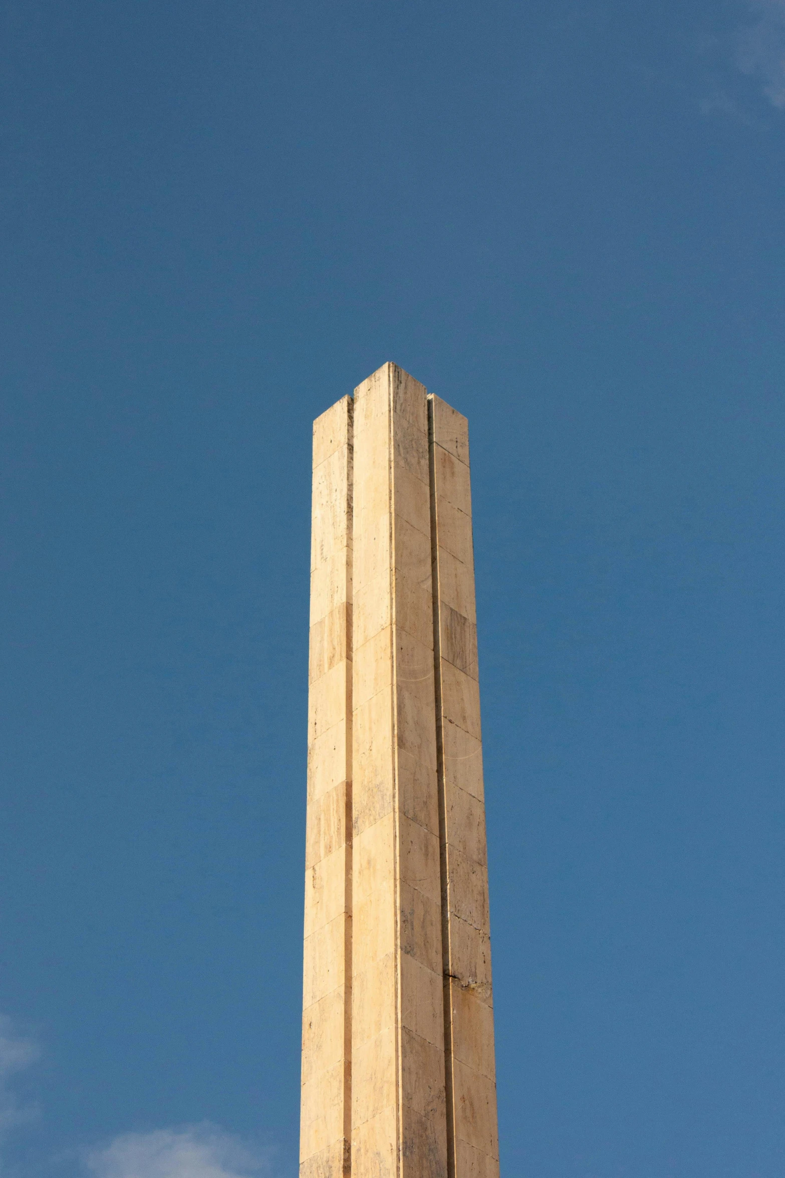 a tall clock tower sits under a blue sky