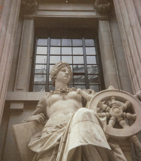 a statue in front of a window on the outside of a building