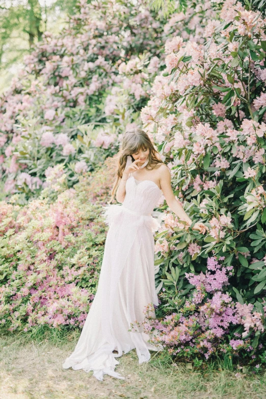 a beautiful woman in white dress posing near flowers