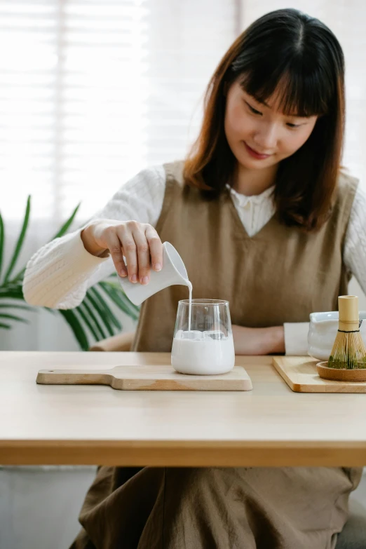 a woman pours a glass with some liquid for her