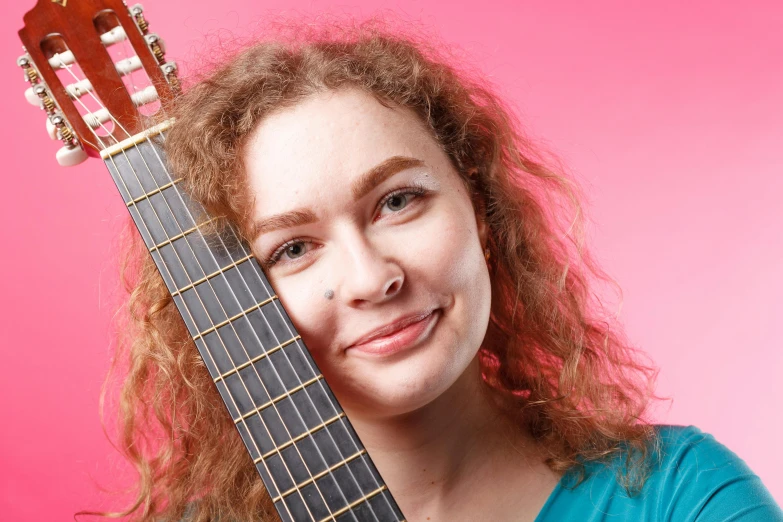 a young lady is playing the guitar with her head resting on the neck