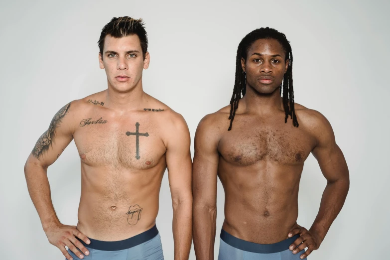 two young men standing together with their shirts open