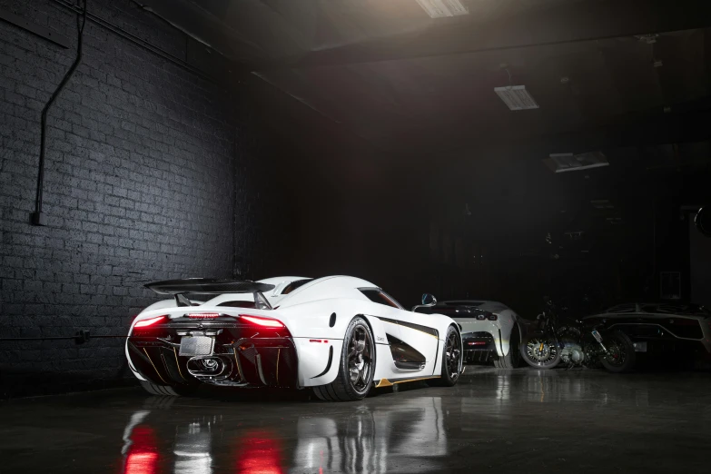 a white car in a garage with it's headlights on