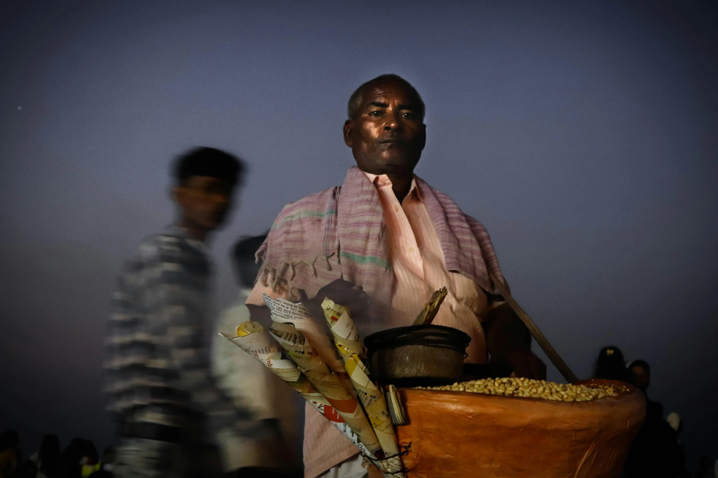 there is a man carrying a large basket full of grains