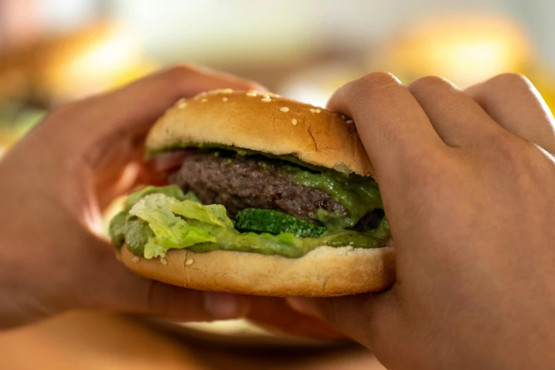 hands holding open a hamburger over the counter