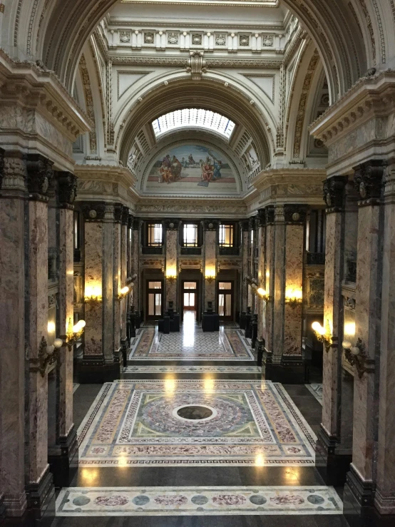 the lobby inside of a large building with a mosaic floor