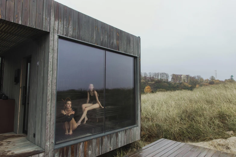 two people are reflected in the windows of a shed