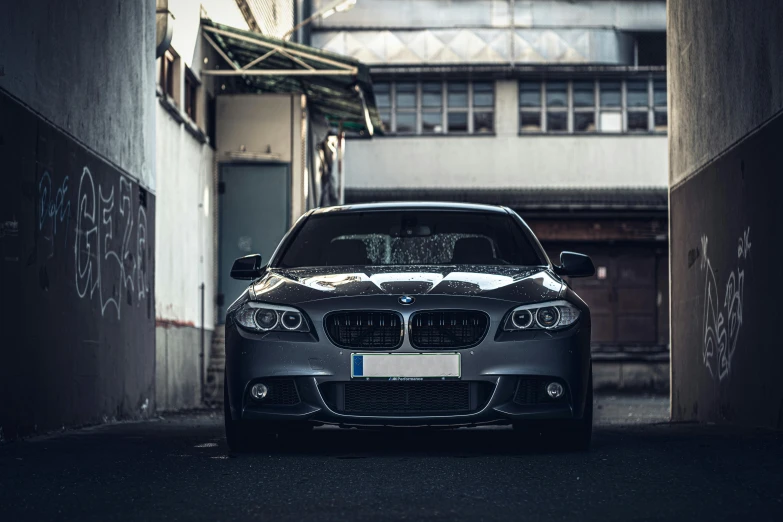 a parked car in an alley next to a wall