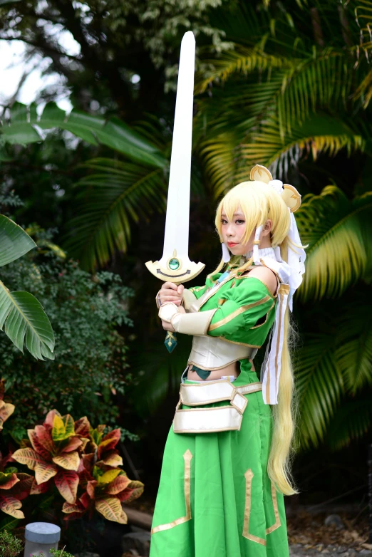the girl is holding her sword and wearing green clothing