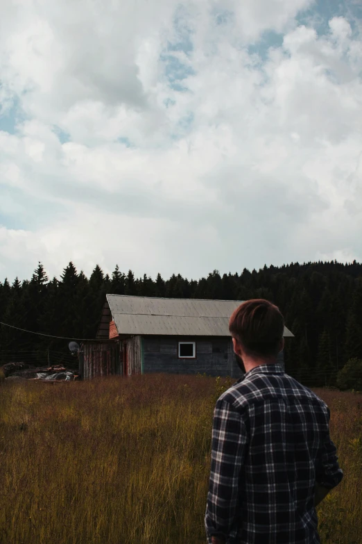 a man standing in a field looking at the sky