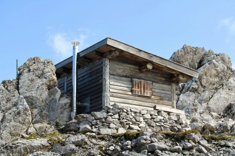 a wooden cabin sitting on top of a rock cliff