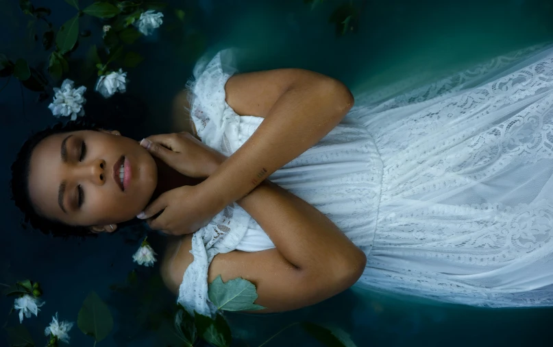 a  in a dress laying on a flowery plant