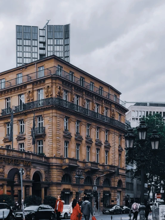 a very tall tan building with a black balcony