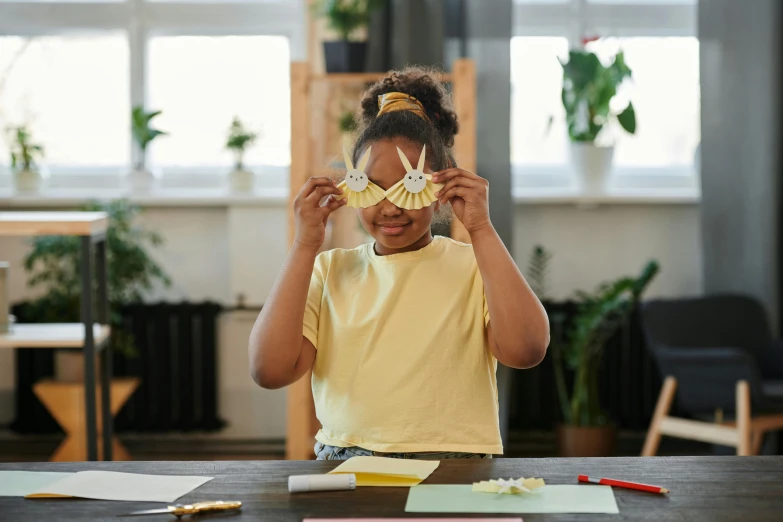  showing off paper plane from behind her eyeglasses