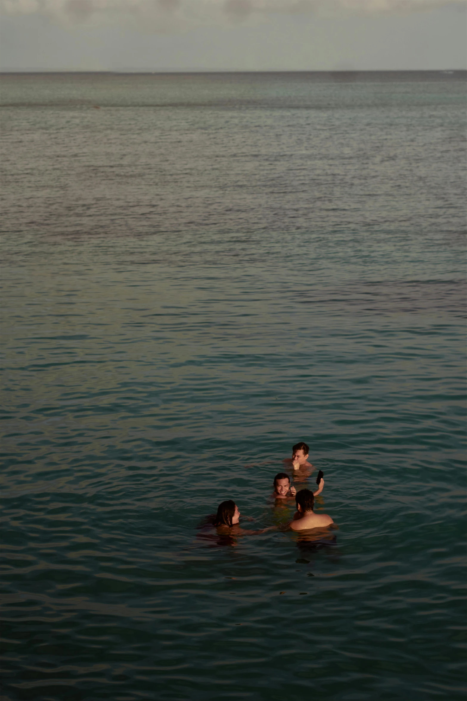 four people are swimming in the sea together