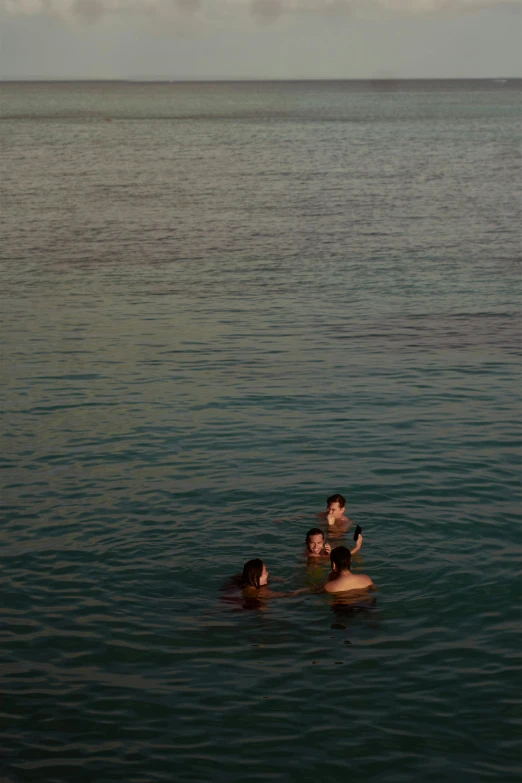 four people are swimming in the sea together