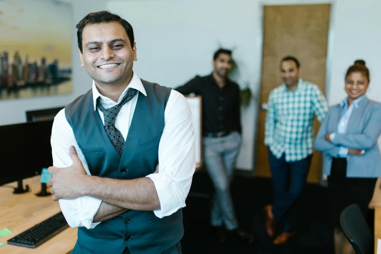 three people in suits and ties, posing in front of a wooden desk