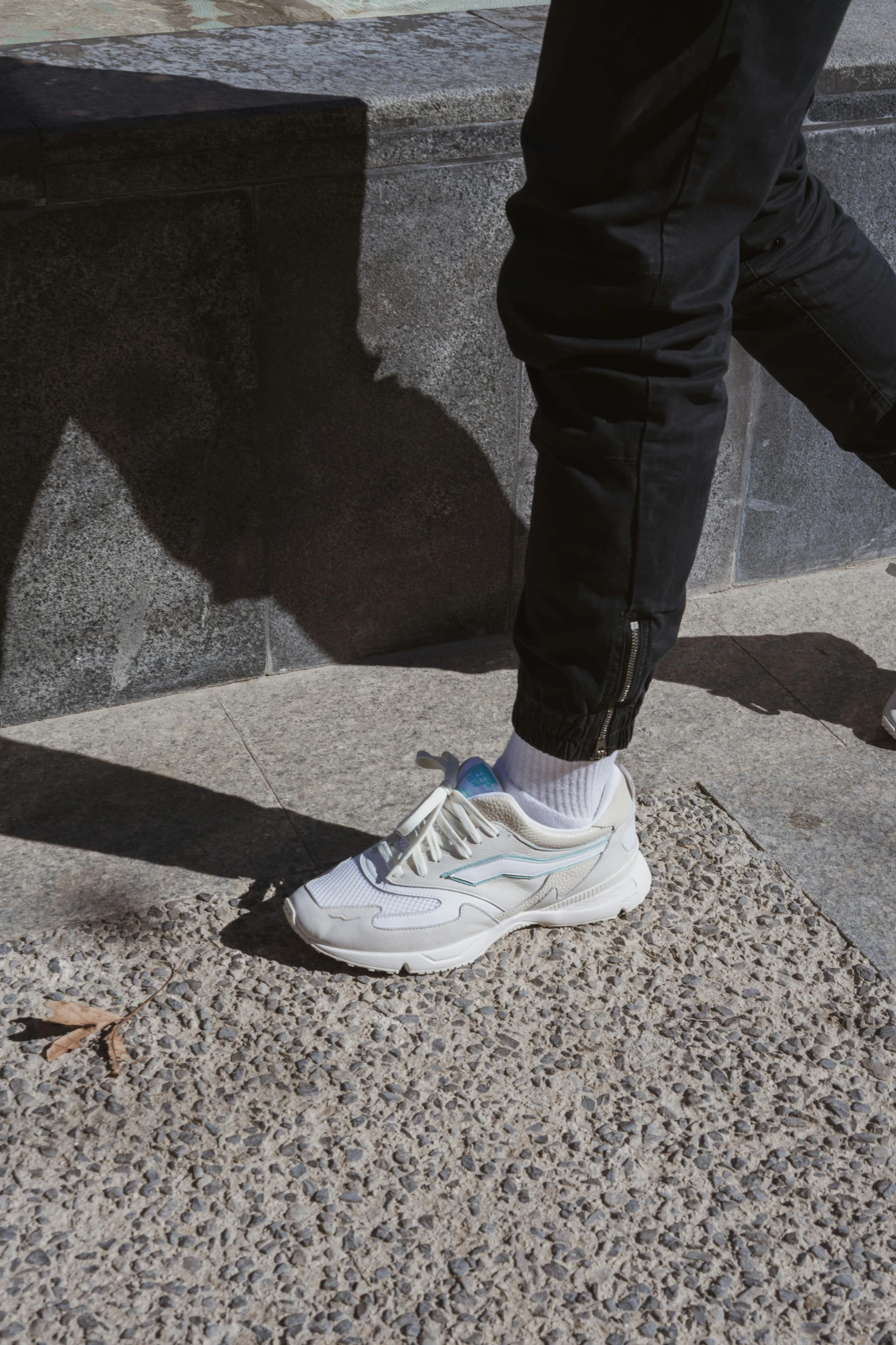 a person with sneakers standing in front of a sidewalk