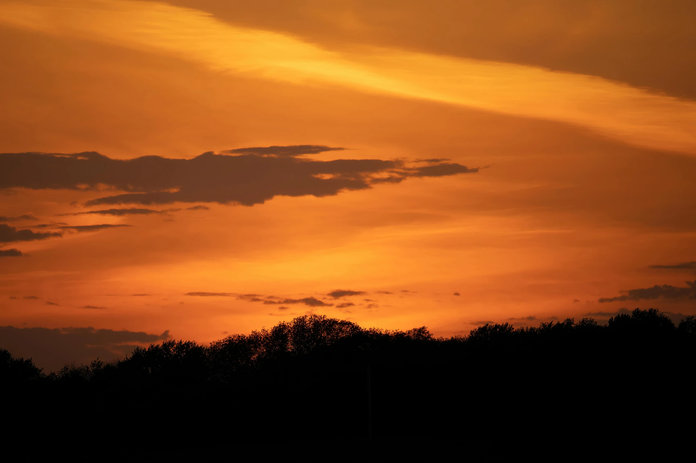 a large plane flying in the air during sunset