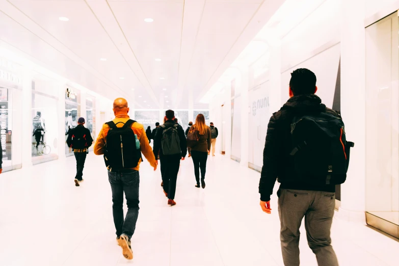 people walking down a long hallway inside a building