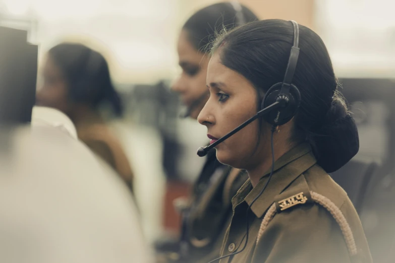 a woman wearing a uniform holding a phone with a headset on