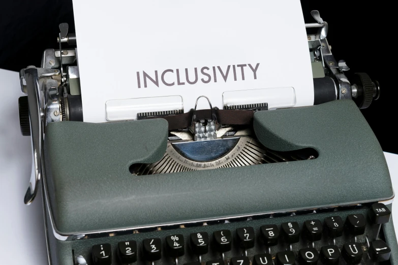 an old - fashioned typewriter has the word inclusivity printed on it