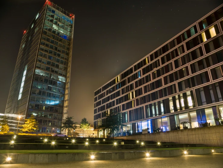 the glass building is lit up and reflecting lights in the windows