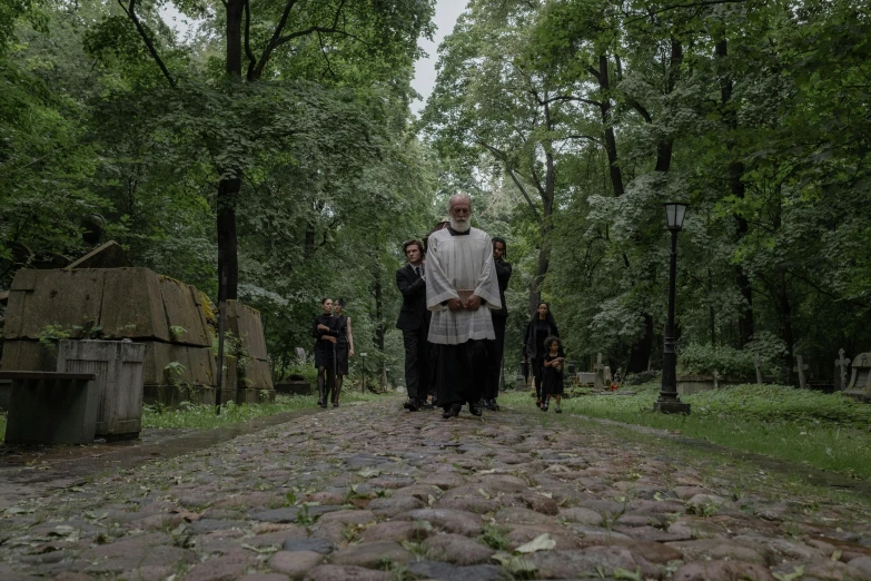 the men are walking in a path surrounded by a forest