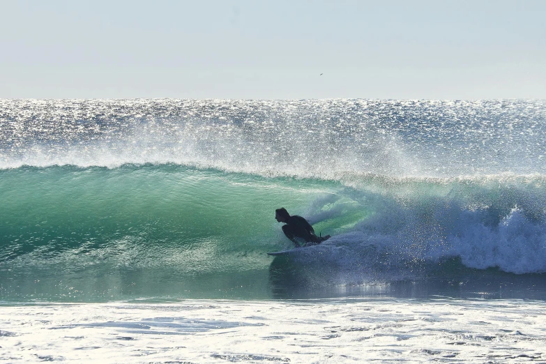 surfer riding large wave at ocean with sprayy water