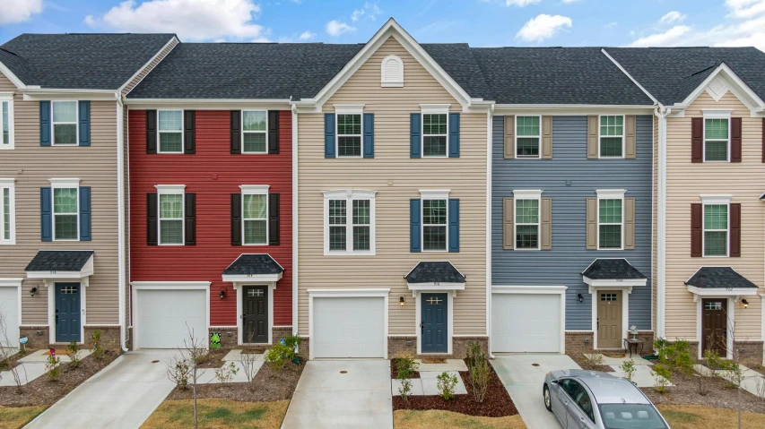 several townhouses with blue and red paint, one car parked in front of the house