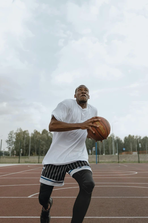 the man is wearing black boots holding a basketball