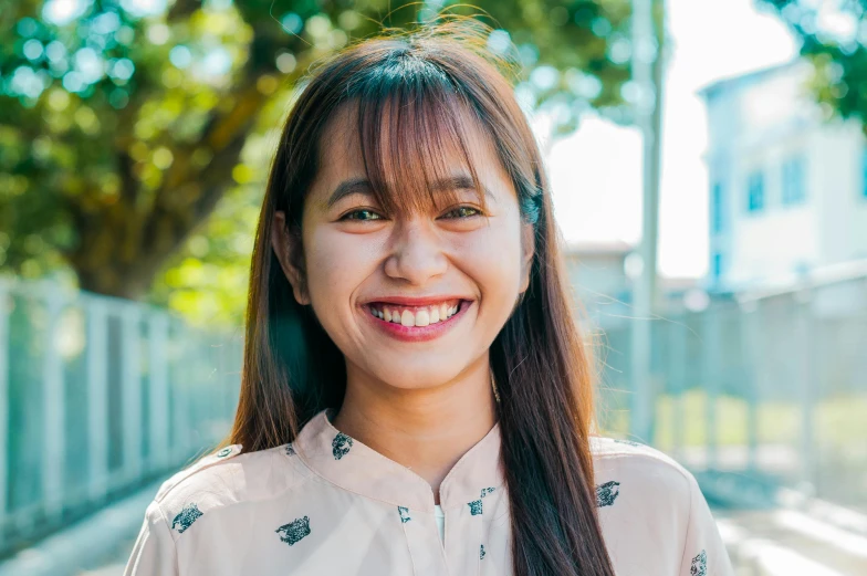 an asian woman with long straight hair wearing a pink shirt