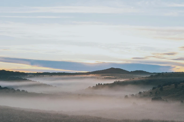 a view of a field covered in clouds at sunset