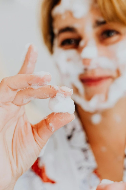 the girl is taking a po of herself with her face cream