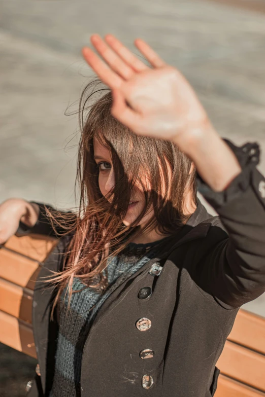 a woman in a gray shirt holds her hands out