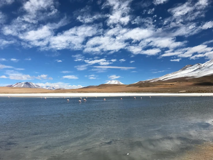 there is a clear expanse of water surrounded by mountains