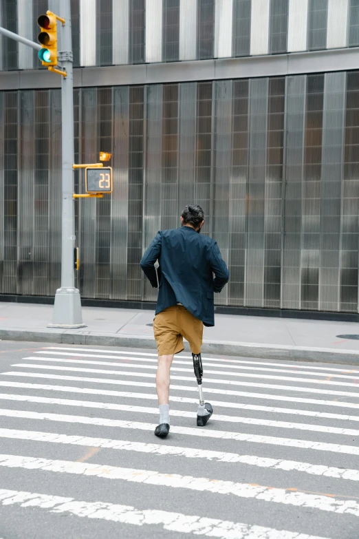 the man in blue is walking on the crosswalk